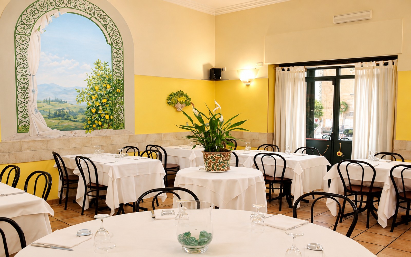 La sala interna con l'arco dipinto a trompe-l'oeil e l'albero di limoni